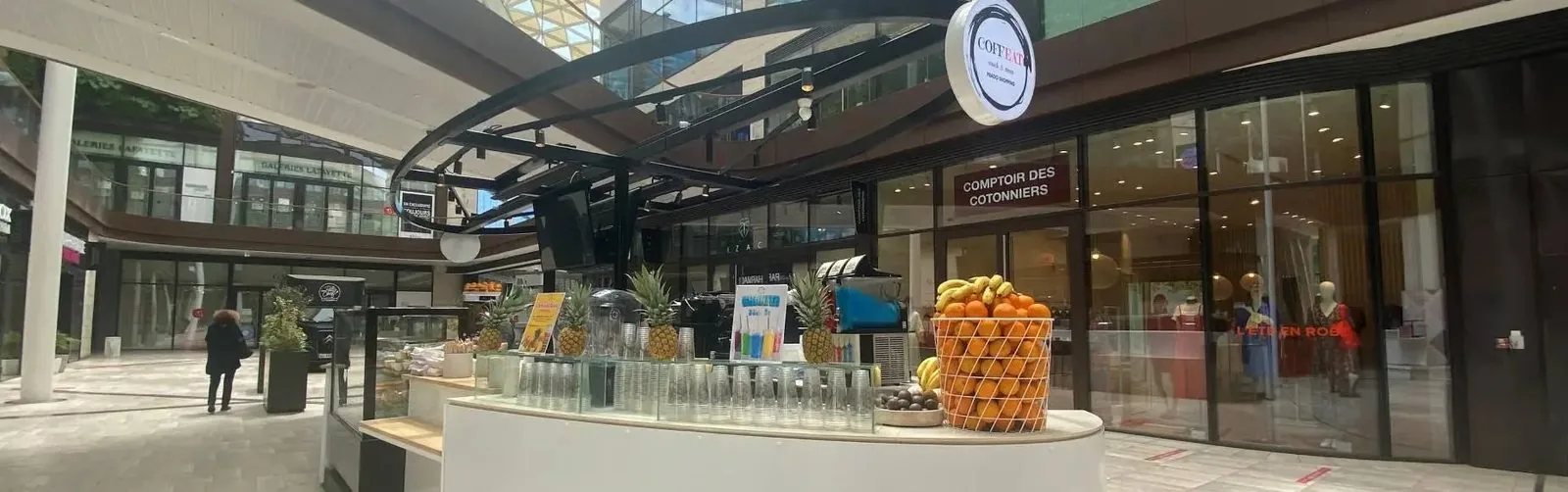 Le kiosque COFFEAT et son enseigne ronde, dans l'allée du centre Prado Shopping